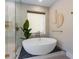 Modern bathroom with a luxurious soaking tub, decorative rock, glass enclosed shower, and chic fixtures at 401 39Th St, Holmes Beach, FL 34217