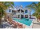 Stunning home exterior featuring a sparkling pool, tropical landscaping, and luxurious outdoor living spaces for ultimate relaxation at 401 39Th St, Holmes Beach, FL 34217