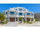 Stunning modern white townhouse with beautiful landscaping and a paver driveway at 401 39Th St, Holmes Beach, FL 34217