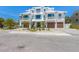Modern three-story townhouse with white exterior, balconies, and a brick paver driveway at 401 39Th St, Holmes Beach, FL 34217