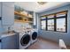 A modern laundry room with front load washer and dryer and built in shelving at 401 39Th St, Holmes Beach, FL 34217