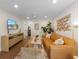 Bright living room featuring a tan leather couch, wood floors, neutral accents, and a wall-mounted television at 401 39Th St, Holmes Beach, FL 34217
