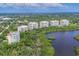 Aerial view of condos overlooking lush greenery and a serene lake at 401 N Point Rd # 504, Osprey, FL 34229