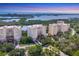 Stunning aerial view of three luxury condominiums with water views and lush landscaping at 401 N Point Rd # 504, Osprey, FL 34229