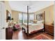Comfortable bedroom with hardwood floors, a four-poster bed, and plenty of natural light creating a peaceful atmosphere at 401 N Point Rd # 504, Osprey, FL 34229