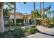 Club house with tile roof surrounded by lush landscaping and palms at 401 N Point Rd # 504, Osprey, FL 34229