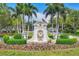 Beautiful community entrance with an eagle statue, American flag, and vibrant flowerbeds at 401 N Point Rd # 504, Osprey, FL 34229