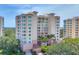 Beautiful exterior shot of condominium building with lush landscaping and manicured lawn at 401 N Point Rd # 504, Osprey, FL 34229