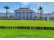 Gorgeous home featuring stately columns, a lush green lawn, and meticulously manicured landscaping at 401 N Point Rd # 504, Osprey, FL 34229