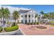 Up close exterior of the clubhouse entry, showcasing grand columns, brick drive and tropical landscaping at 401 N Point Rd # 504, Osprey, FL 34229