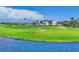 Beautiful golf course view with clubhouse, manicured green, sand trap and lake on a sunny day at 401 N Point Rd # 504, Osprey, FL 34229