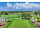 View of lush green golf course showing a tee box, palm trees, and manicured fairways on a sunny day with scattered clouds at 401 N Point Rd # 504, Osprey, FL 34229