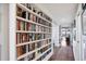 Hallway featuring floor-to-ceiling bookshelves, hardwood flooring, and a decorative rug at 401 N Point Rd # 504, Osprey, FL 34229