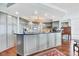 Spacious kitchen with gray cabinets, backsplash, modern appliances, island, and hardwood floors at 401 N Point Rd # 504, Osprey, FL 34229