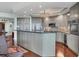 Spacious kitchen with gray cabinets, backsplash, modern appliances, island, and a decorative chandelier at 401 N Point Rd # 504, Osprey, FL 34229