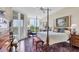 Bedroom with a four-poster bed, hardwood floors, and a sitting area with views of the outdoors at 401 N Point Rd # 504, Osprey, FL 34229