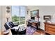 Comfortable office featuring natural light, a wooden desk, and views of a lush green treeline and waterway at 401 N Point Rd # 504, Osprey, FL 34229