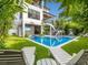 Inviting backyard featuring a sparkling pool, comfortable lounge chairs, and lush landscaping at 421 Alamanda Rd, Anna Maria, FL 34216