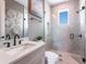 Stylish bathroom featuring a mosaic-tiled shower and modern vanity with sleek fixtures and decorative wall art at 421 Alamanda Rd, Anna Maria, FL 34216
