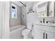Bathroom with white subway tile in shower and sleek white vanity at 421 Alamanda Rd, Anna Maria, FL 34216