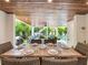 Outdoor dining area with wood-paneled ceiling and a view of the backyard and pool area at 421 Alamanda Rd, Anna Maria, FL 34216