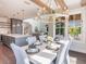 Elegant dining room with wood beams, designer chandelier, seating for six and view to living room at 421 Alamanda Rd, Anna Maria, FL 34216