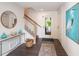 Inviting foyer with elegant decor, featuring stylish console table, mirror, and staircase leading to upper levels at 421 Alamanda Rd, Anna Maria, FL 34216