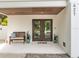 Welcoming front entrance with double doors, a wooden bench, and a wood-paneled ceiling at 421 Alamanda Rd, Anna Maria, FL 34216