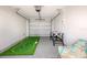 Finished garage features a putting green, foosball table, speckled floor, and overhead door at 421 Alamanda Rd, Anna Maria, FL 34216