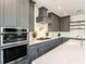 Modern kitchen with gray cabinets, stainless steel appliances, and white quartz countertops at 421 Alamanda Rd, Anna Maria, FL 34216