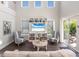 Bright living room with high ceilings, built-in shelving, and sliding glass doors leading to an outdoor patio at 421 Alamanda Rd, Anna Maria, FL 34216