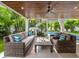Covered outdoor living area with comfortable seating, stairs to a pool, and tropical landscaping at 421 Alamanda Rd, Anna Maria, FL 34216