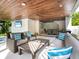 Inviting outdoor living space with comfortable seating, a TV, and a view of the pool at 421 Alamanda Rd, Anna Maria, FL 34216