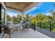 Relaxing covered patio with comfortable seating and views of the lush tropical landscape at 421 Alamanda Rd, Anna Maria, FL 34216