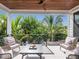 Inviting covered patio with cozy seating overlooking the beautiful tropical foliage at 421 Alamanda Rd, Anna Maria, FL 34216