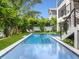 Backyard swimming pool featuring an integrated staircase, tiled details, and lush landscaping at 421 Alamanda Rd, Anna Maria, FL 34216
