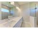 Bright bathroom features double vanity, framed mirror, and glass-enclosed walk-in shower at 4210 Sea Marsh Pl, Parrish, FL 34219