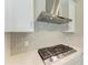 Close-up of a gas cooktop with stainless steel hood and attractive tile backsplash at 4210 Sea Marsh Pl, Parrish, FL 34219