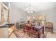 Elegant dining room featuring a round chandelier and unique decor pieces on an eye-catching accent cabinet at 4374 Indian Point Trl, Sarasota, FL 34238