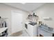 Bright laundry room featuring white washer and dryer set, utility sink, and convenient shelving for supplies at 4637 31St E Ct, Bradenton, FL 34203