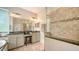 Bathroom featuring a glass enclosed shower, double sinks, and stone floors at 5044 Creekside Trl, Sarasota, FL 34243