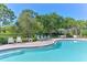 Community pool with clear water, lounge chairs, brick trim, and lush landscaping at 5044 Creekside Trl, Sarasota, FL 34243