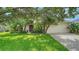 Charming home featuring a lush green lawn, mature trees, and a neatly landscaped front yard at 5044 Creekside Trl, Sarasota, FL 34243