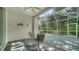 Covered lanai with textured flooring and seating area overlooks a lush, green yard at 5044 Creekside Trl, Sarasota, FL 34243