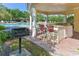 Outdoor kitchen with bar, grill, and seating area offers an ideal spot for entertaining near pool at 5044 Creekside Trl, Sarasota, FL 34243