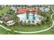Overhead view of resort-style community pool with red tile roofed clubhouse, a playground, and walking paths at 5213 Patano Loop, Palmetto, FL 34221