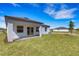 Back exterior features a covered patio, green lawn, and neutral-colored exterior at 5213 Patano Loop, Palmetto, FL 34221