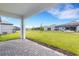 View of the brick paver patio looking out over the expansive lawn, perfect for outdoor entertaining at 5213 Patano Loop, Palmetto, FL 34221