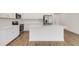 Open kitchen with island, white cabinets, tile floors, and stainless steel appliances at 5213 Patano Loop, Palmetto, FL 34221