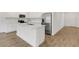 Kitchen with island, white cabinetry, stainless appliances, quartz countertop, and tile flooring at 5213 Patano Loop, Palmetto, FL 34221